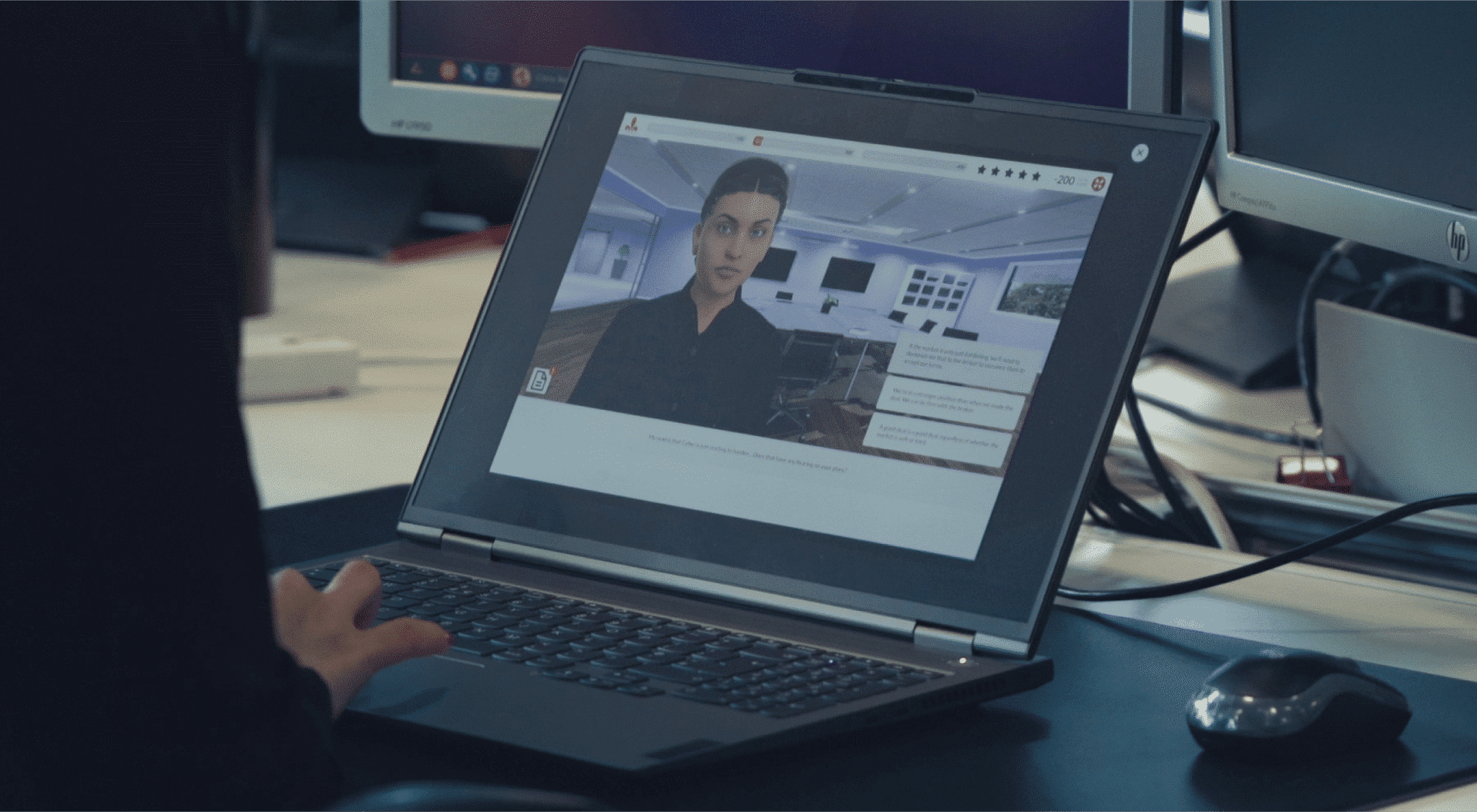 En dataskjerm viser en video av en karakter fra Hiscox sin spillbaserte opplæring utviklet av Attensi